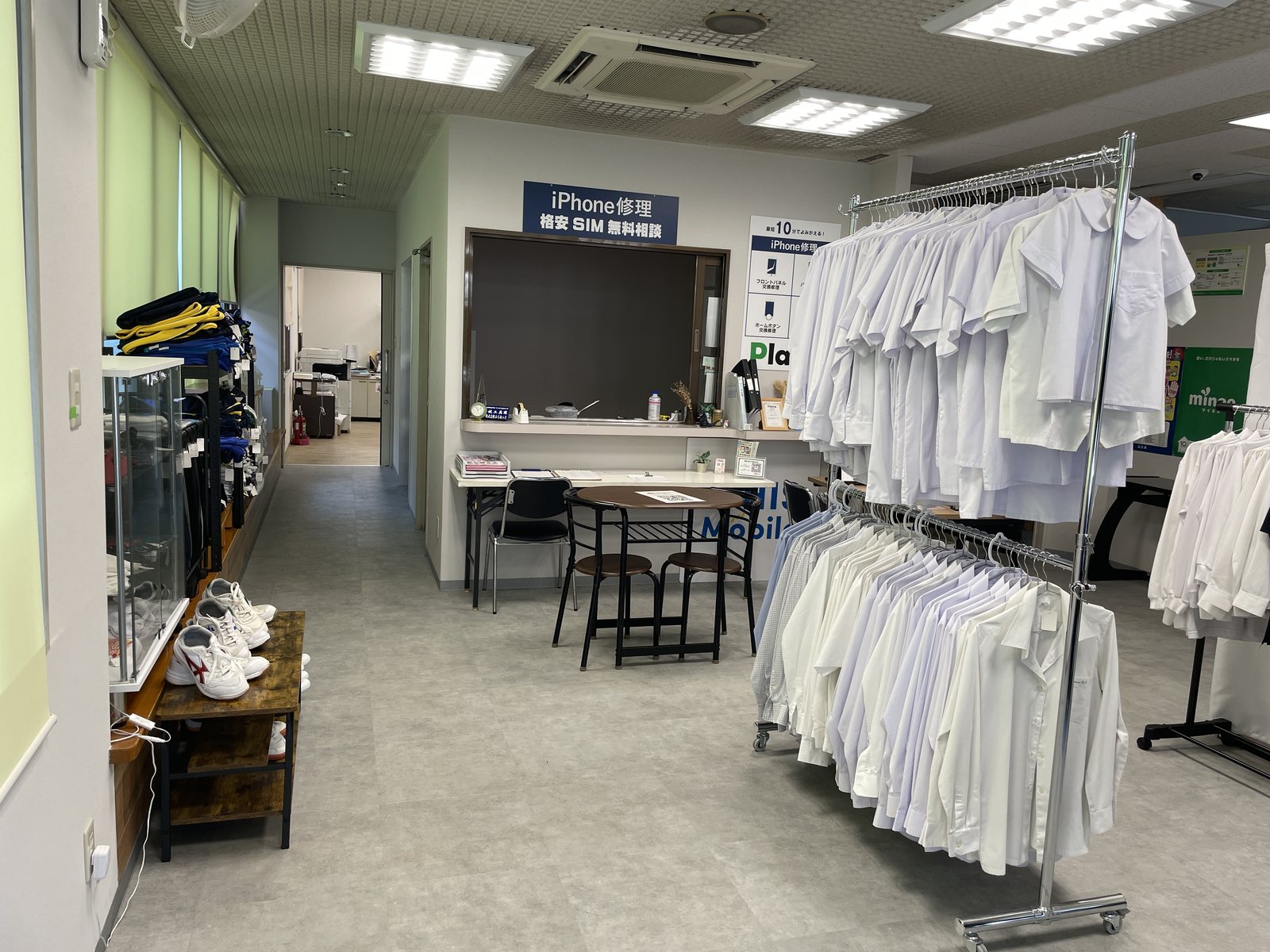 店内の様子。手前に制服リユースのシャツが並び、奥に携帯クリニックの修理の受付がある